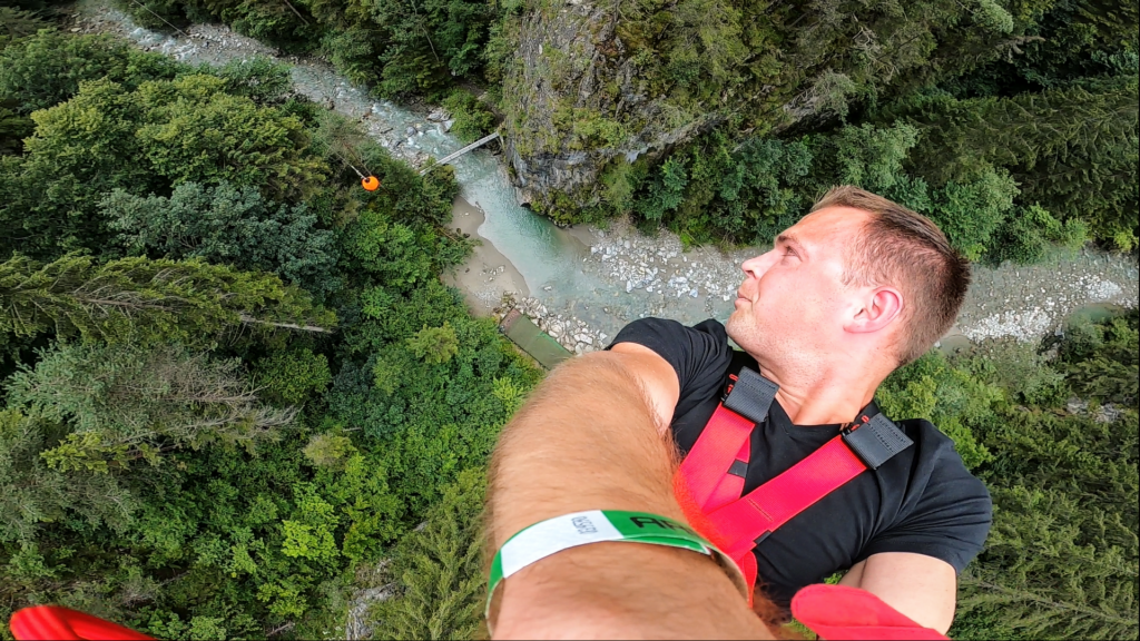 Człowiek podczas skoku bungee patrzący się na wąwóz i rzekę